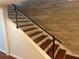Modern staircase featuring dark wood treads, white risers, and sleek black metal railings at 416 Howard Ave # D, Lakeland, FL 33815