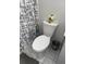 Cozy bathroom features a standard toilet with modern gray shower curtain and white tiling at 426 Cardinal Ct, Kissimmee, FL 34759