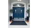 Stylish blue double front door with sidelights, decorative plants, and lanterns create a welcoming entrance at 426 Cardinal Ct, Kissimmee, FL 34759