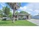 Charming single-story home featuring a well-manicured front yard and covered porch with seating at 4520 W Oak Ridge Rd, Orlando, FL 32809