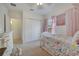 Bright bedroom features carpet, closet and colorful bedding and matching pink curtains at 4899 Meadow Dr, St Cloud, FL 34772