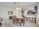 Open dining area with a wooden table, white tiled floor, and connected breakfast bar at 4899 Meadow Dr, St Cloud, FL 34772