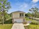 View of house with two-car garage, walkway and fenced backyard at 4899 Meadow Dr, St Cloud, FL 34772