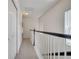 Well-lit hallway featuring neutral carpet and railings with access to multiple rooms at 4899 Meadow Dr, St Cloud, FL 34772