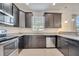 A modern kitchen with stainless steel appliances, granite countertops, and stylish dark cabinets at 4899 Meadow Dr, St Cloud, FL 34772