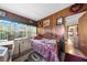Bedroom featuring wood paneled walls, a window with blinds, and a bed with a purple comforter at 517 Carolina Ave, St Cloud, FL 34769