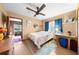 Bedroom featuring a ceiling fan, a window with blue curtains, and a small table with a lamp at 517 Carolina Ave, St Cloud, FL 34769
