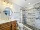 Updated bathroom featuring marble vanity, tile shower, and pebble shower floor at 5452 Higgins Way, Orlando, FL 32808