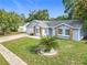 Charming single-story home with light blue siding, brick accents, and a well-manicured lawn under a sunny sky at 5452 Higgins Way, Orlando, FL 32808
