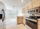 Well-lit kitchen featuring stainless steel appliances and light wood cabinetry at 5452 Higgins Way, Orlando, FL 32808