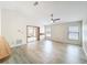 Open-concept living room featuring wood floors, fan, and bright, sun-filled windows at 5452 Higgins Way, Orlando, FL 32808