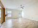 Open floor plan with wood floors, a ceiling fan and two large windows at 5452 Higgins Way, Orlando, FL 32808