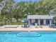 Community pool with a bright blue water, a small covered lounge, and ample seating and tables at 5452 Higgins Way, Orlando, FL 32808
