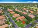 Neighborhood aerial showcasing well-maintained homes with red roofs, mature landscaping, and a scenic golf course at 572 Sienna Dr, Poinciana, FL 34759