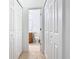 Hallway view into a bright bathroom with a toilet and vanity, framed by white closet doors at 572 Sienna Dr, Poinciana, FL 34759