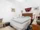 Well-lit bedroom with a decorative bed, bedside tables, and framed artwork on the walls at 572 Sienna Dr, Poinciana, FL 34759