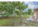 Backyard with lush greenery, lawn, and various trees at 600 Regency Way, Kissimmee, FL 34758