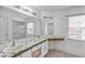 Bathroom with a double sink vanity, large mirror, and glass-enclosed shower at 600 Regency Way, Kissimmee, FL 34758