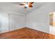 Bedroom with a ceiling fan, wood-look flooring, and access to another room at 600 Regency Way, Kissimmee, FL 34758