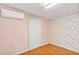 Cozy bedroom with wood floor, patterned wallpaper, and mini-split AC unit at 600 Regency Way, Kissimmee, FL 34758