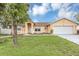 Charming single-story home with a well-manicured lawn and attached two car garage at 600 Regency Way, Kissimmee, FL 34758