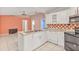 Open kitchen and living area with white cabinets, stainless steel appliances, and open floor plan at 600 Regency Way, Kissimmee, FL 34758