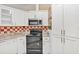 Lovely kitchen with stainless appliances, tile backsplash, and white cabinets for storage at 600 Regency Way, Kissimmee, FL 34758