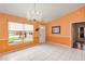 Living room with neutral tile floors, a large window, and chandelier above at 600 Regency Way, Kissimmee, FL 34758