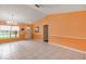Living room with neutral tile floors, a large window, and chandelier above at 600 Regency Way, Kissimmee, FL 34758