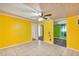 Open concept living room with bright yellow walls and tile flooring at 600 Regency Way, Kissimmee, FL 34758
