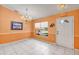 Living room with neutral tile floors, a large window, and chandelier above at 600 Regency Way, Kissimmee, FL 34758