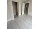 This is a bedroom with neutral wall paint, and tile flooring and includes a closet with a white bifold door at 702 Michigan Ct # 4, St Cloud, FL 34769