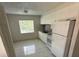 White kitchen with tiled flooring, stylish backsplash, modern appliances, and natural light at 702 Michigan Ct # 4, St Cloud, FL 34769