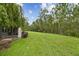 Expansive backyard with lush green grass and views of mature trees and manicured landscaping at 726 Irvine Ranch Rd, Kissimmee, FL 34759
