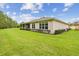 Exterior view showcases the home's rear facade, manicured lawn, and inviting screened-in porch at 726 Irvine Ranch Rd, Kissimmee, FL 34759