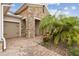 Close-up of front entry, showcasing stone pillars, brick walkway, and lush tropical landscaping at 726 Irvine Ranch Rd, Kissimmee, FL 34759