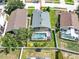 An aerial view of a house with a screened-in pool area, surrounded by green lawns and neighboring houses at 737 Oxford Dr, Davenport, FL 33897