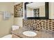 Stylish bathroom with a granite countertop, decorative tile backsplash, and framed mirror at 737 Oxford Dr, Davenport, FL 33897