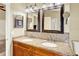 Bathroom showing a double sink vanity with granite countertop, decorative framed mirrors and ample lighting at 737 Oxford Dr, Davenport, FL 33897