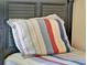 Closeup of a twin bed with colorful striped bedding and decorative pillow at 737 Oxford Dr, Davenport, FL 33897