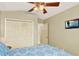 Cozy bedroom with a TV, closet, ceiling fan and light-colored walls at 737 Oxford Dr, Davenport, FL 33897