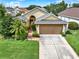 Charming single-Gathering home showcasing a well-manicured lawn and a two-car garage on a sunny day at 737 Oxford Dr, Davenport, FL 33897