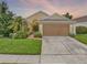 Charming single-Gathering home showcasing a well-manicured lawn and a two-car garage at 737 Oxford Dr, Davenport, FL 33897