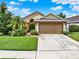 Charming single-Gathering home with well-maintained lawn, mature landscaping, and a two-car garage at 737 Oxford Dr, Davenport, FL 33897