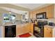 A bright kitchen is decorated with stainless steel appliances, granite countertops, and tan cabinets at 737 Oxford Dr, Davenport, FL 33897