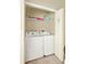 A stacked washer and dryer in a closet with laundry supplies and extra storage space at 737 Oxford Dr, Davenport, FL 33897