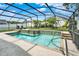 Screened-in pool area boasts a sparkling pool, spa, and lush landscaping, creating a private outdoor oasis at 737 Oxford Dr, Davenport, FL 33897