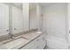 Bathroom featuring dual sink vanity, granite counters, white cabinetry and tiled shower with glass door at 7554 Sunflower Cir, Kissimmee, FL 34747