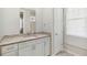 Bathroom vanity with granite countertop, white cabinets, chrome hardware and a large mirror at 7554 Sunflower Cir, Kissimmee, FL 34747