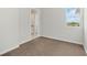 Bright bedroom with plush carpeting, a window offering scenic views, and access to an adjacent bathroom at 7554 Sunflower Cir, Kissimmee, FL 34747
